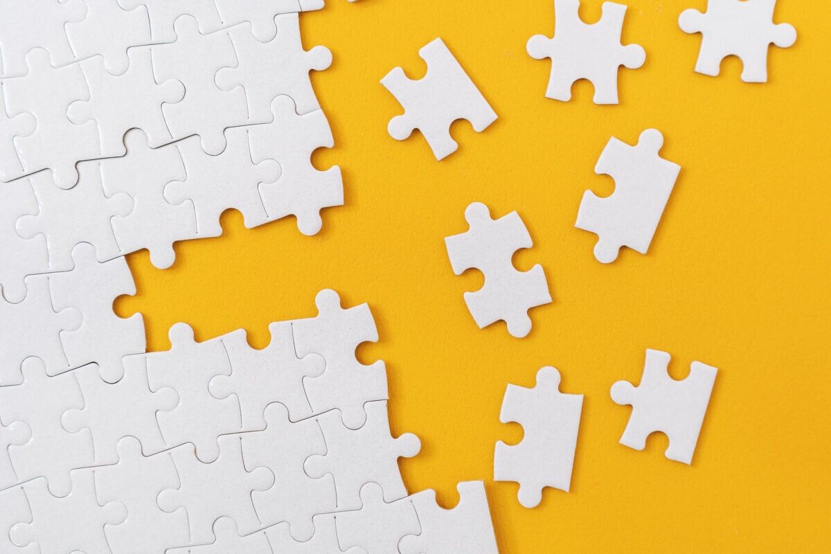 Partially complete jigsaw puzzle with scattered missing pieces