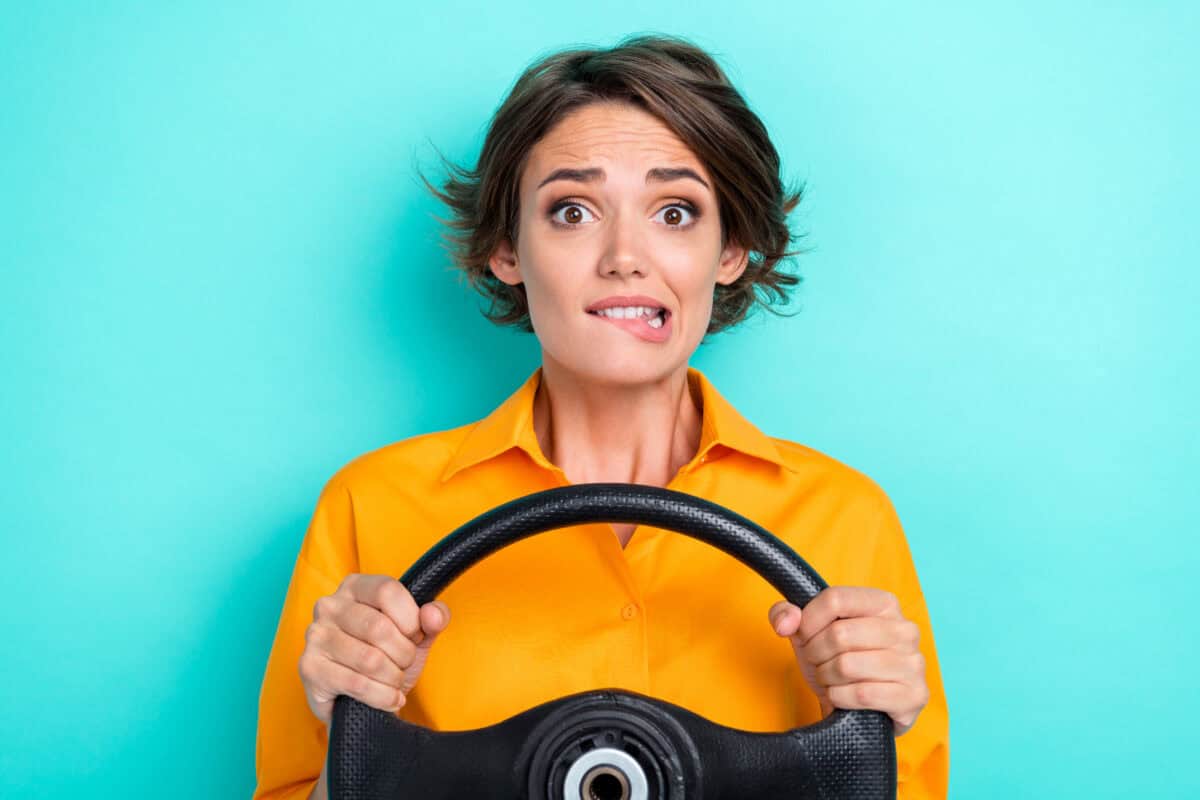 woman holding steering wheel is nervous about the future