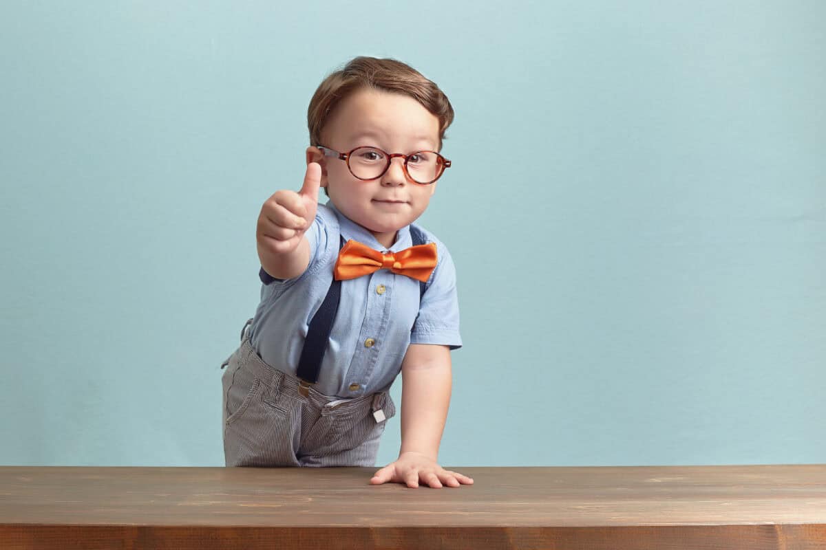 boy in bowtie and glasses gives positive thumbs up