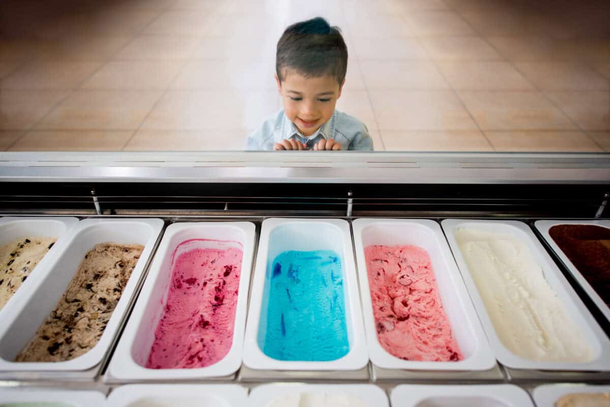 child looks at variety of flavors at ice cream store
