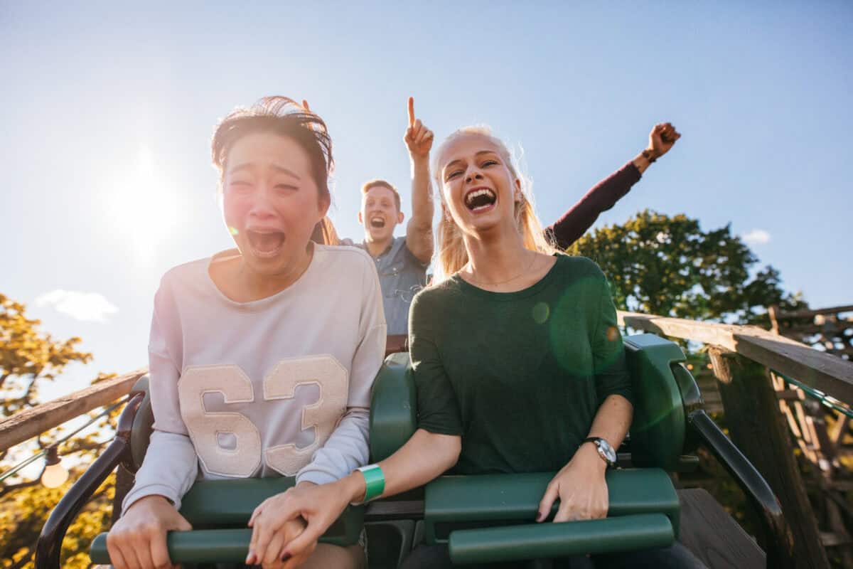 people ride a downhill dip on a roller coaster