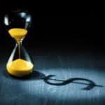 Hourglass projecting a dollar sign as shadow